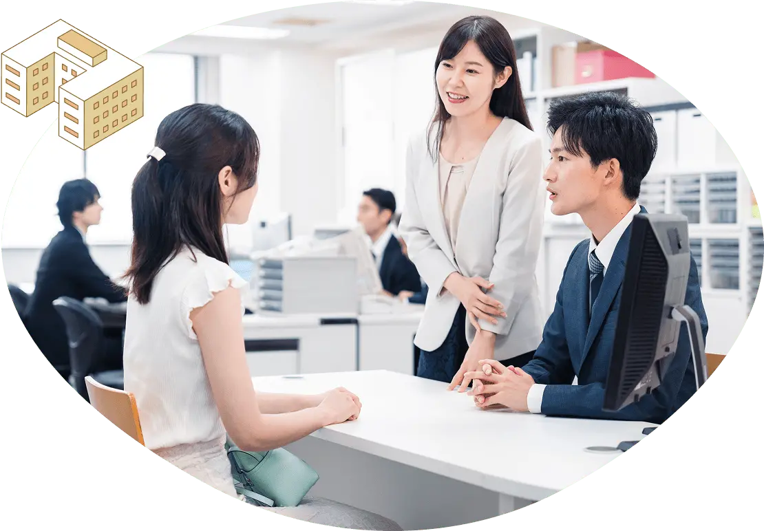 オフィス内で女性と男性の担当者が向かい合って相談をしている様子を写した写真。